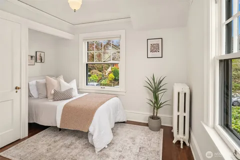 a bedroom with a large bed and a potted plant