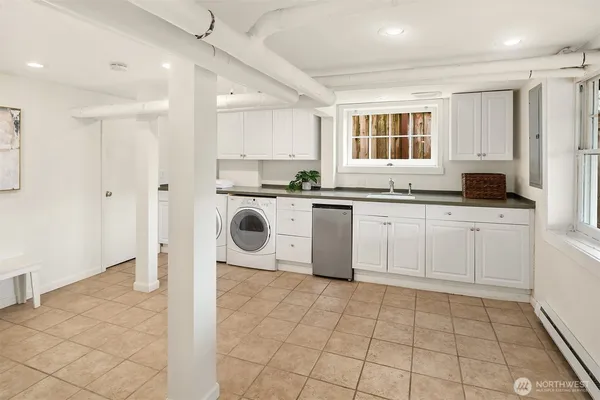 a kitchen with stainless steel appliances granite countertop a sink a stove a refrigerator and white cabinets