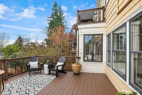 a balcony with wooden floor table and chairs