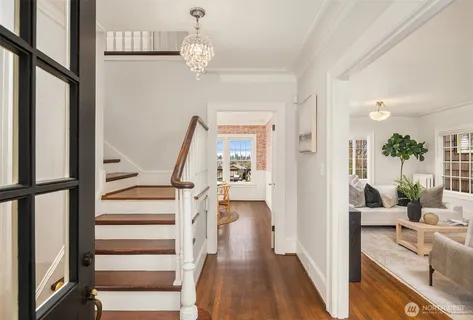 a view of a hallway with wooden floor and staircase