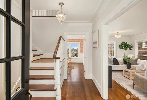 a view of a hallway with wooden floor and staircase