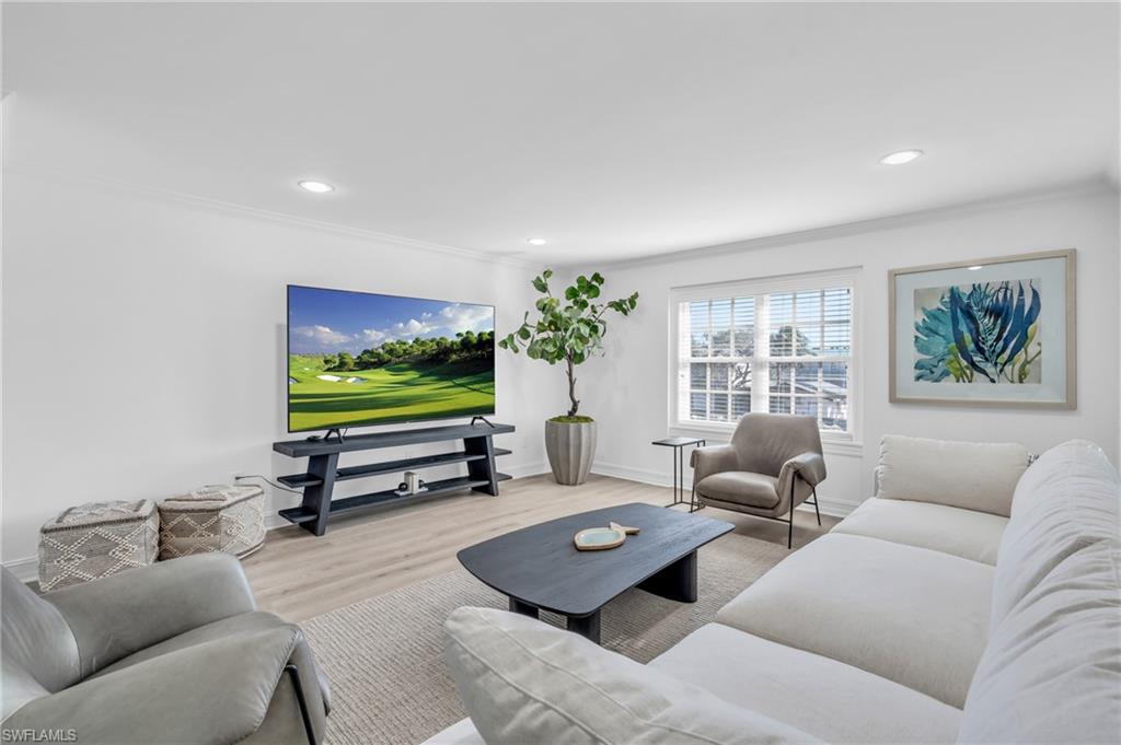 271 Broad Avenue South, Unit 203 Naples, FL 34102 - Photo 2 of 16 a living room with furniture and a flat screen tv