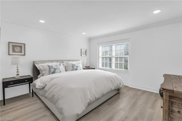 a large bed sitting in a bedroom next to a window with a dresser