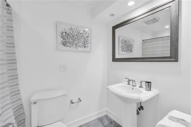 a bathroom with a sink mirror and toilet