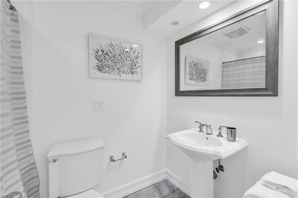 271 Broad Avenue South, Unit 203 Naples, FL 34102 - Photo 10 of 16 a bathroom with a sink mirror and toilet