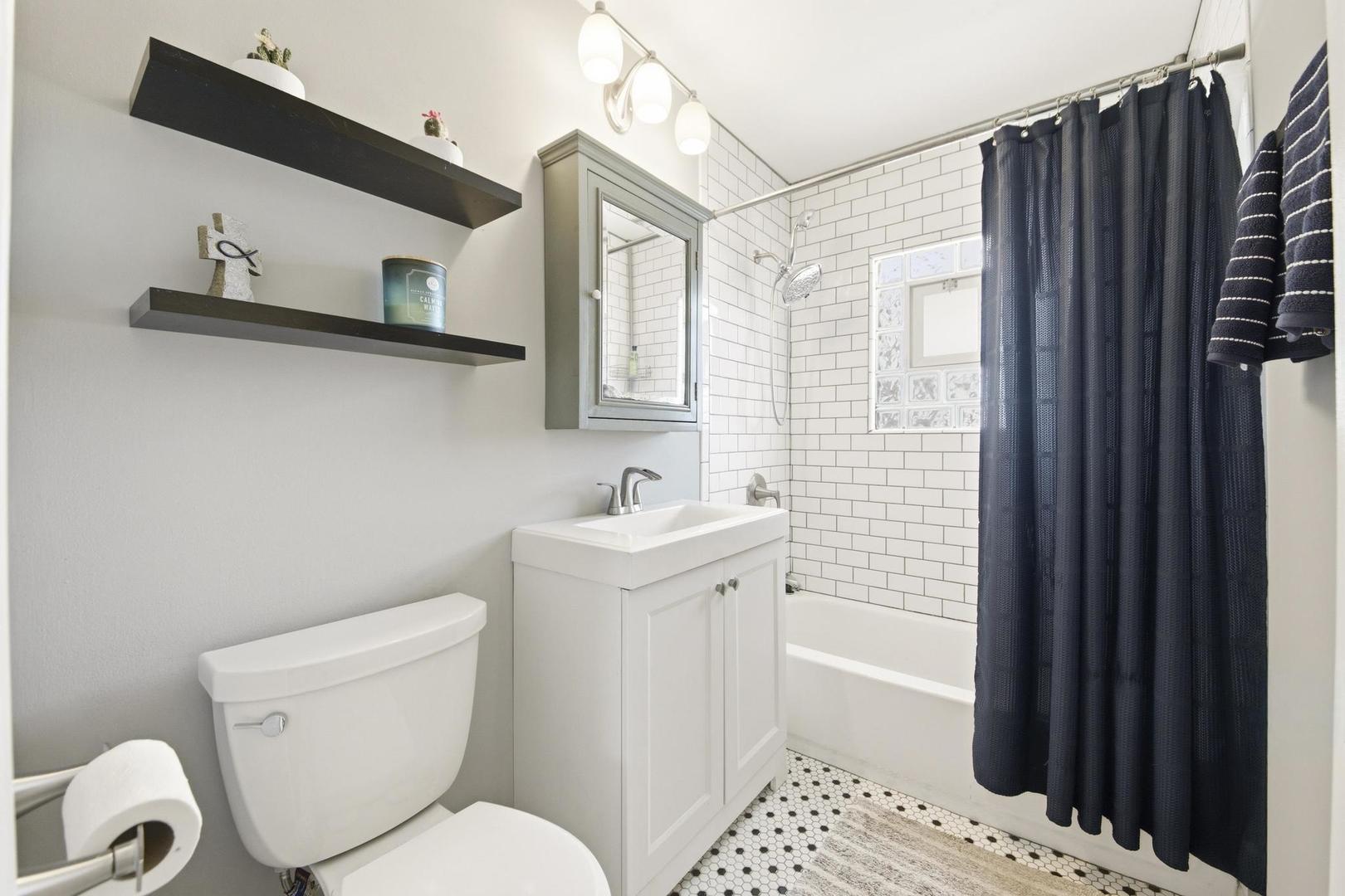 581 Charing Cross Road Elk Grove Village, IL 60007 - Photo 12 of 18 a bathroom with a sink toilet and shower