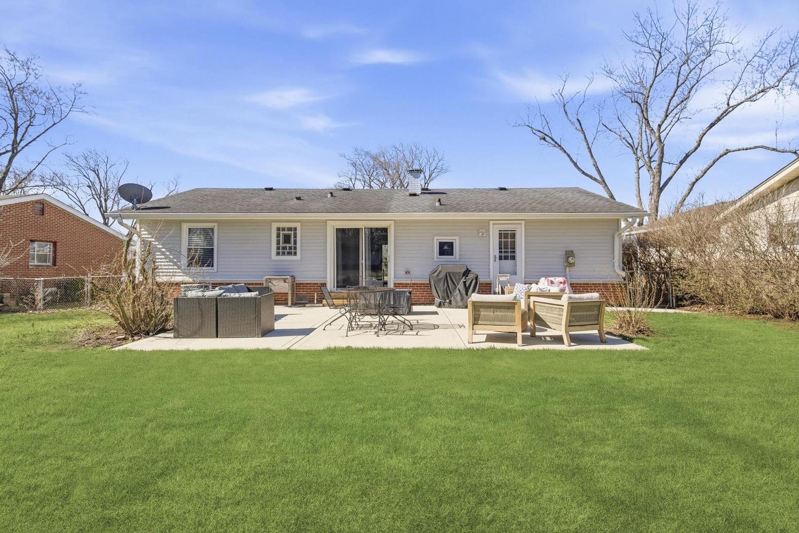 581 Charing Cross Road Elk Grove Village, IL 60007 - Photo 16 of 18 a view of a house with a patio and a yard