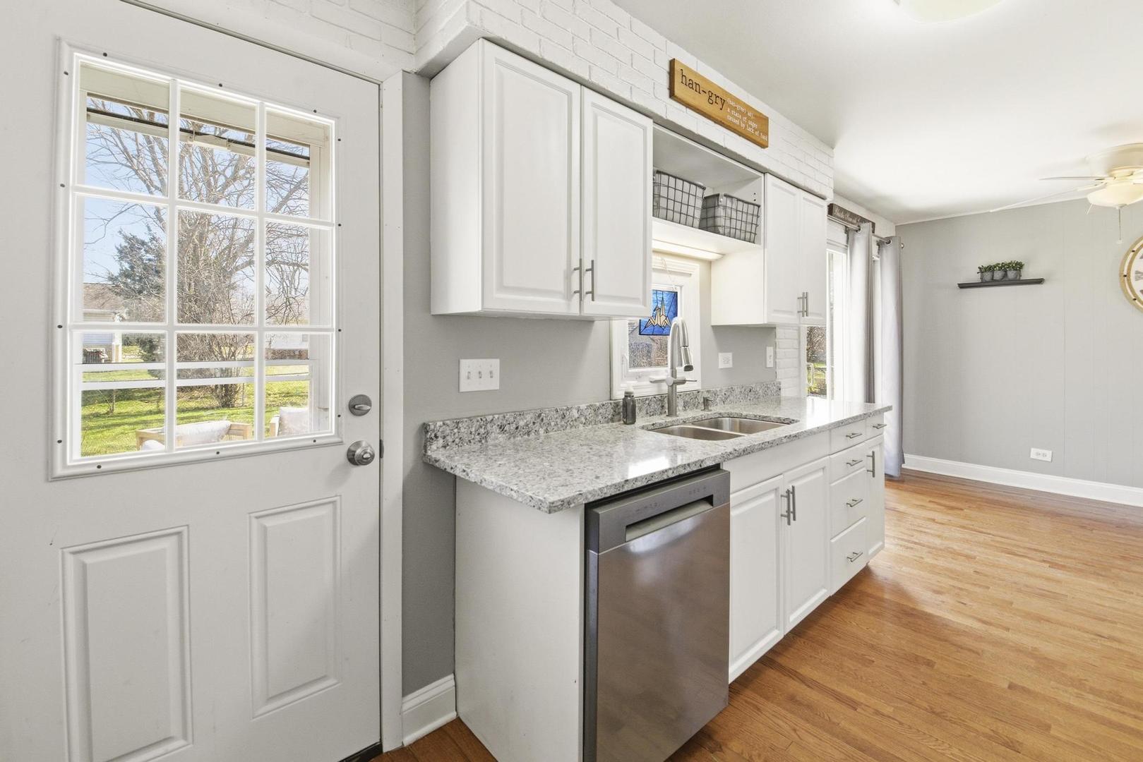 581 Charing Cross Road Elk Grove Village, IL 60007 - Photo 7 of 18 a kitchen with granite countertop cabinets stainless steel appliances a sink and a large window