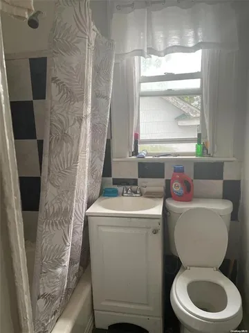 a bathroom with a toilet sink and mirror