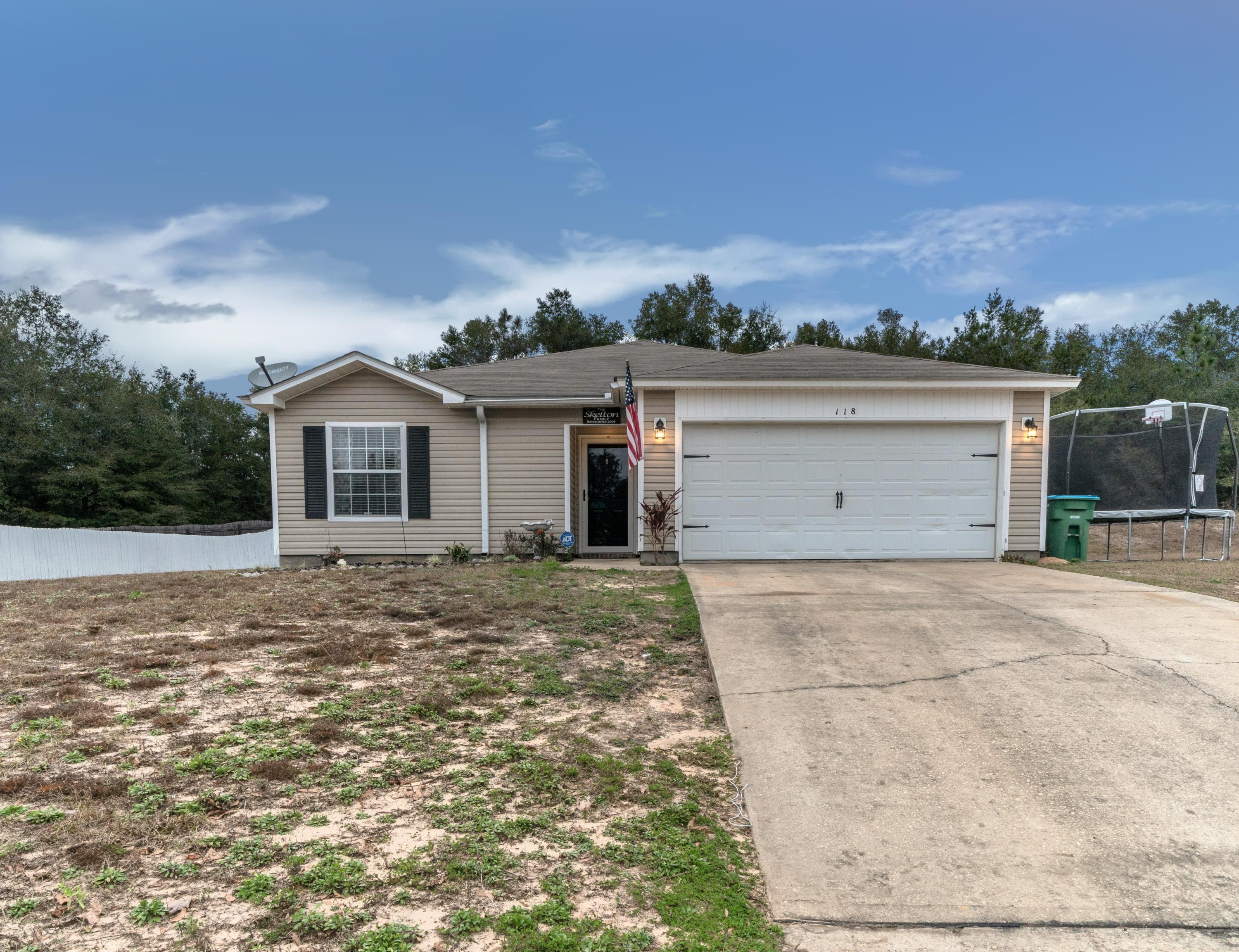 a view of a house with a yard and a garage