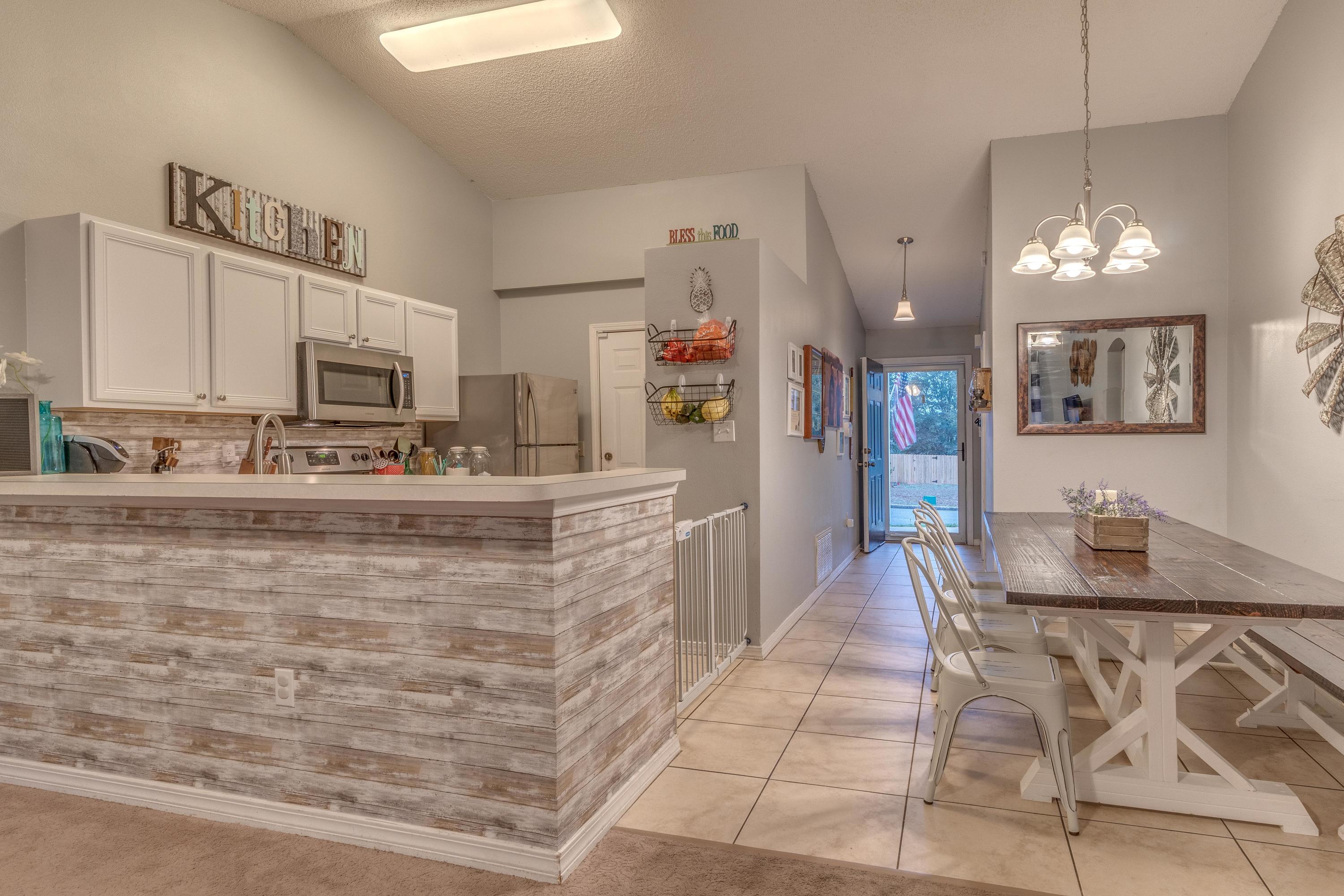 118 Cabana Way Crestview, FL 32536 - Photo 10 of 22 a kitchen with stainless steel appliances kitchen island granite countertop a refrigerator a stove a oven with white cabinets and wooden floor