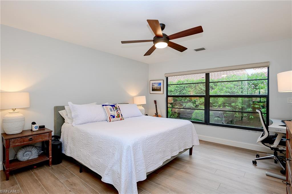 719 Reef Point Circle, Unit 13 Naples, FL 34108 - Photo 16 of 29 a bedroom with a bed and a large window