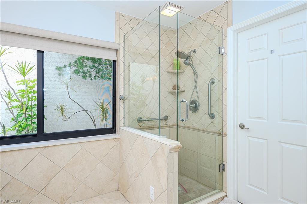 719 Reef Point Circle, Unit 13 Naples, FL 34108 - Photo 19 of 29 a bathroom with a bathtub and a shower