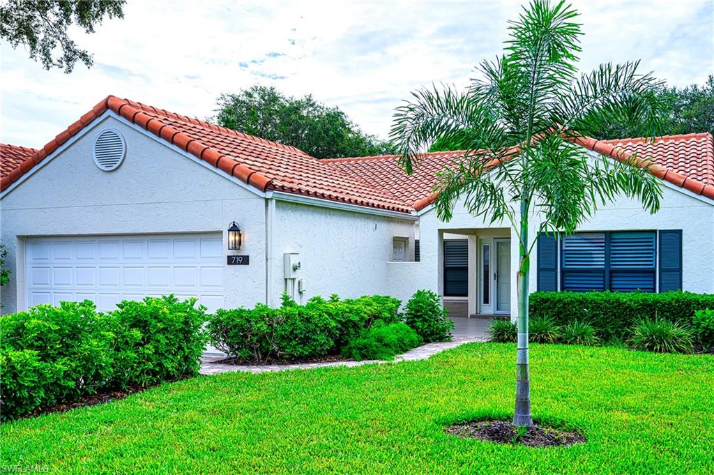 719 Reef Point Circle, Unit 13 Naples, FL 34108 - Photo 2 of 29 a house that has a tree in front of it