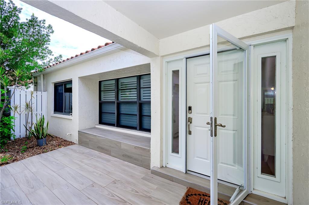 719 Reef Point Circle, Unit 13 Naples, FL 34108 - Photo 4 of 29 wooden floor and glass door in front of house