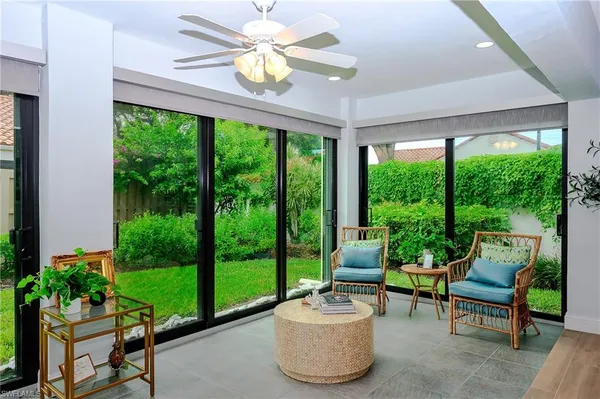 a living room with patio furniture and garden view