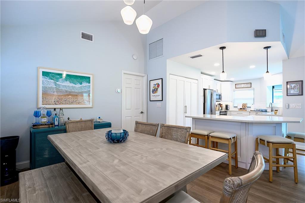 719 Reef Point Circle, Unit 13 Naples, FL 34108 - Photo 7 of 29 a kitchen with a table chairs and wooden floor