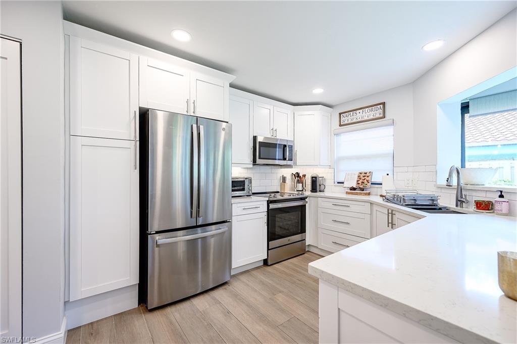 719 Reef Point Circle, Unit 13 Naples, FL 34108 - Photo 8 of 29 a kitchen with a refrigerator stove and sink