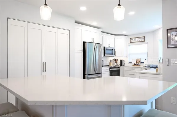 a large white kitchen with a large window