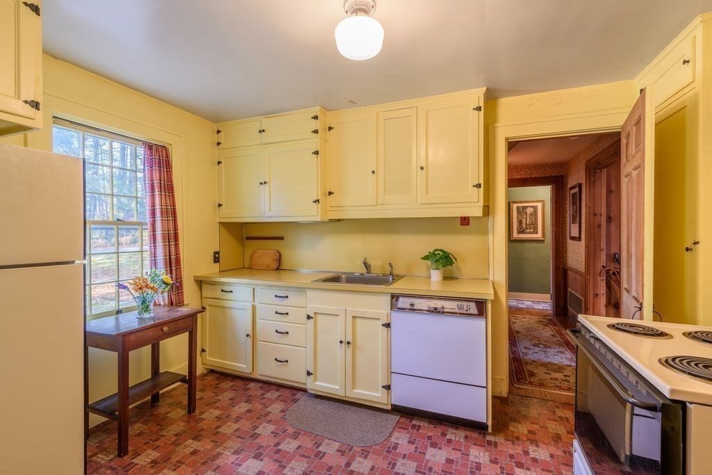 88 Farview Way Amherst, MA 01002 - Photo 4 of 25 a kitchen with granite countertop a stove a sink and a refrigerator
