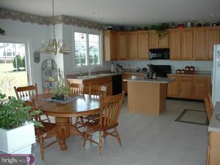 15 Shamrock Road Lumberton, NJ 08048 - Photo 3 of 6 a kitchen with kitchen island granite countertop a table chairs stove and cabinets