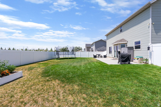 1393 West 150 North Springville, UT 84663 - Photo 19 of 31 Expansive backyard featuring a large lawn, full vinyl privacy fence, and concrete patio