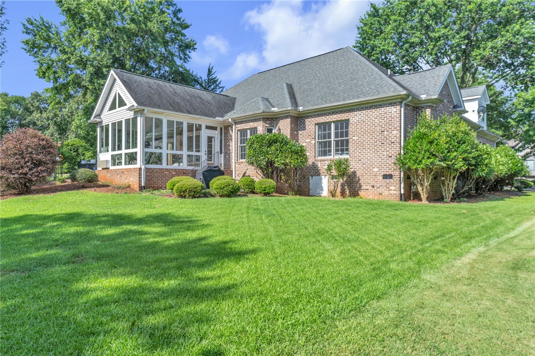 102 Country Walk Lane Clemson, SC 29631 - Photo 31 of 39 An inviting sunroom addition complements this traditional brick home surrounded by a verdant lawn.