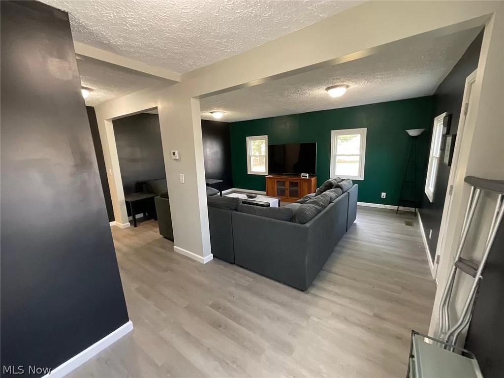1850 Ronald Road Akron, OH 44312 - Photo 10 of 32 Living room featuring a textured ceiling and light hardwood / wood-style floors