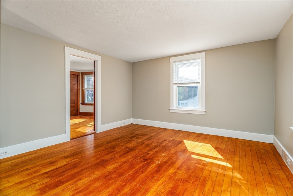 306 Franklin Road Fitchburg, MA 01420 - Photo 20 of 32 a view of an empty room with wooden floor and a window