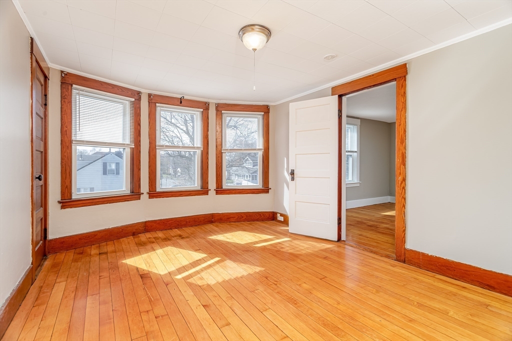 306 Franklin Road Fitchburg, MA 01420 - Photo 3 of 32 a view of an empty room with wooden floor and a window