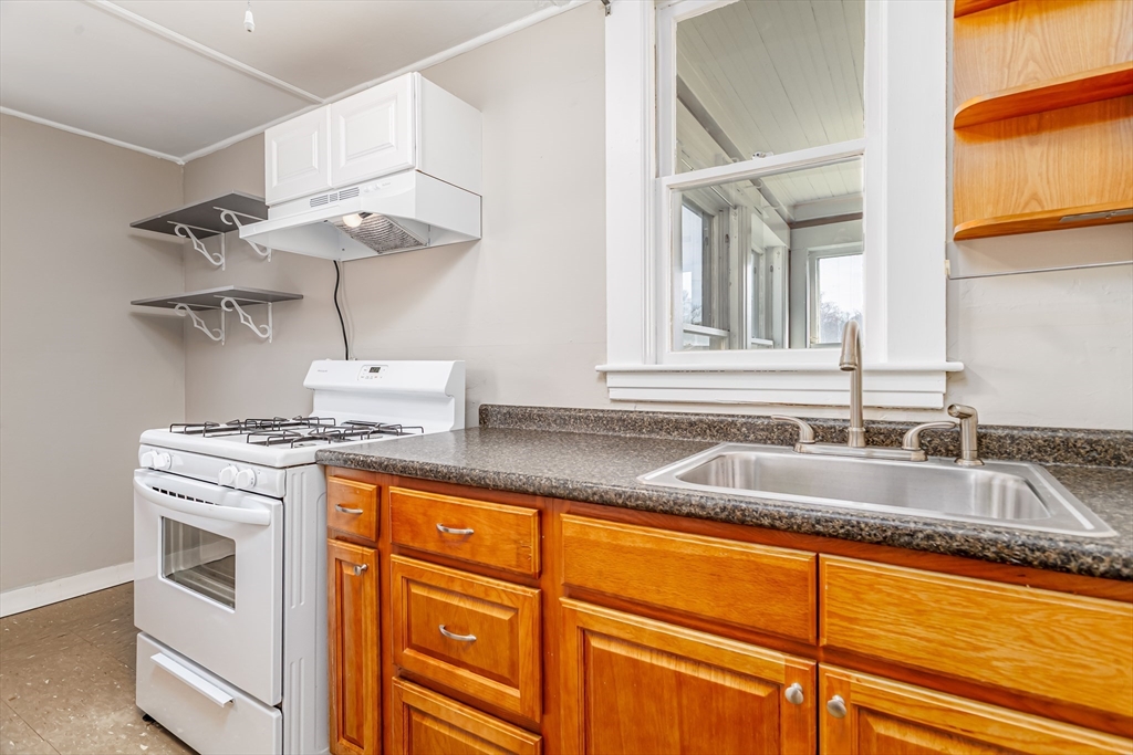 306 Franklin Road Fitchburg, MA 01420 - Photo 5 of 32 a kitchen with granite countertop a sink a stove and cabinets