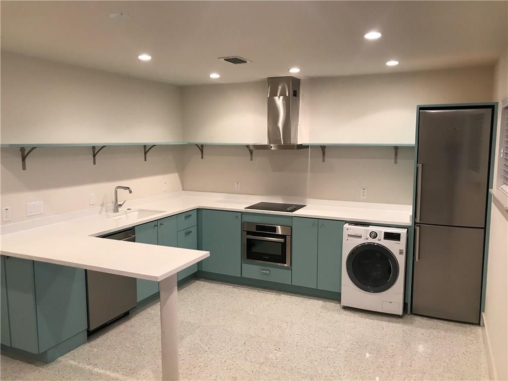 a kitchen with a sink a refrigerator and cabinets