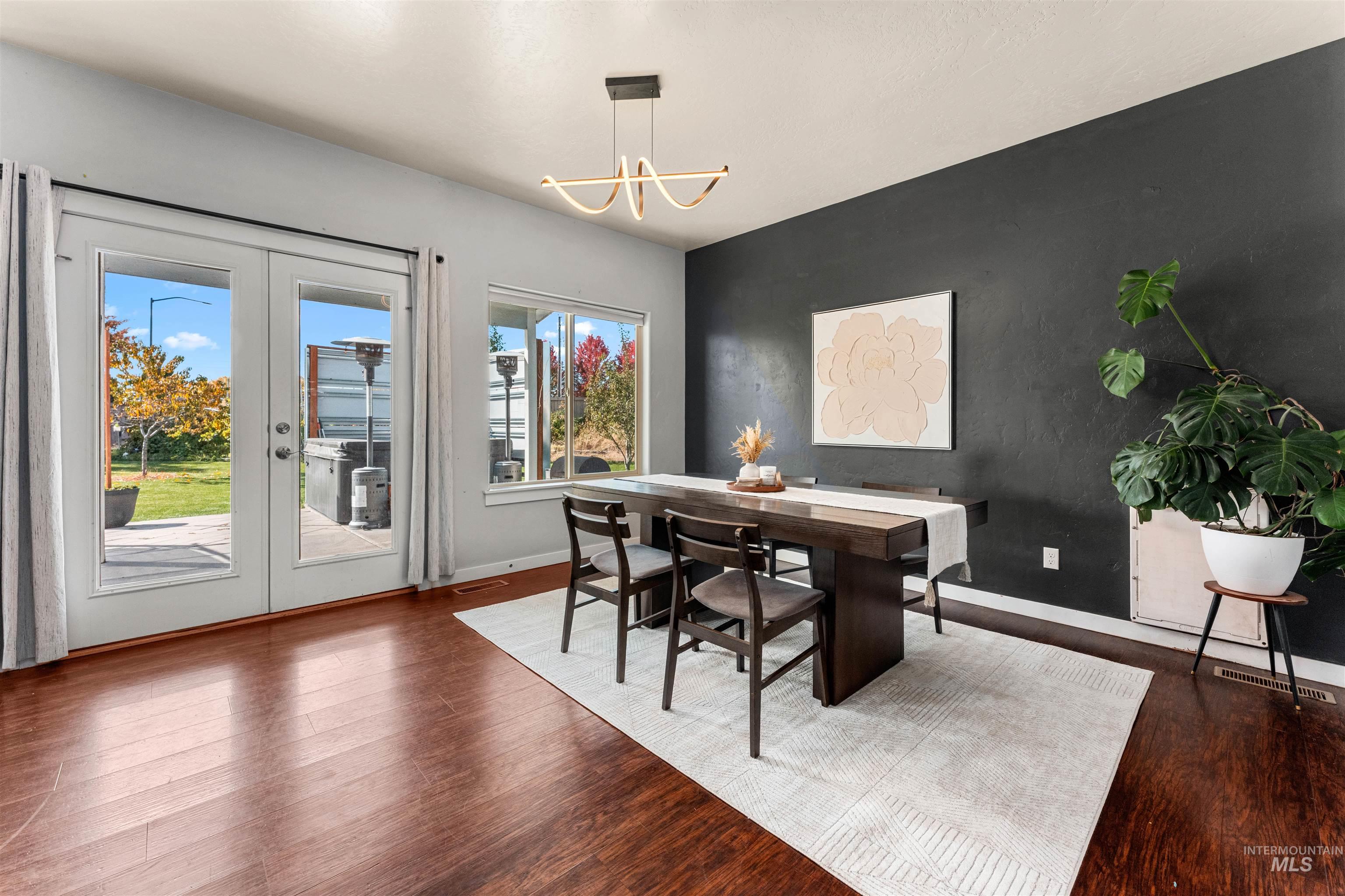 37 East Ensenada Drive Meridian, ID 83646 - Photo 16 of 46 Dining area with dark wood-style flooring, french doors, and a chandelier