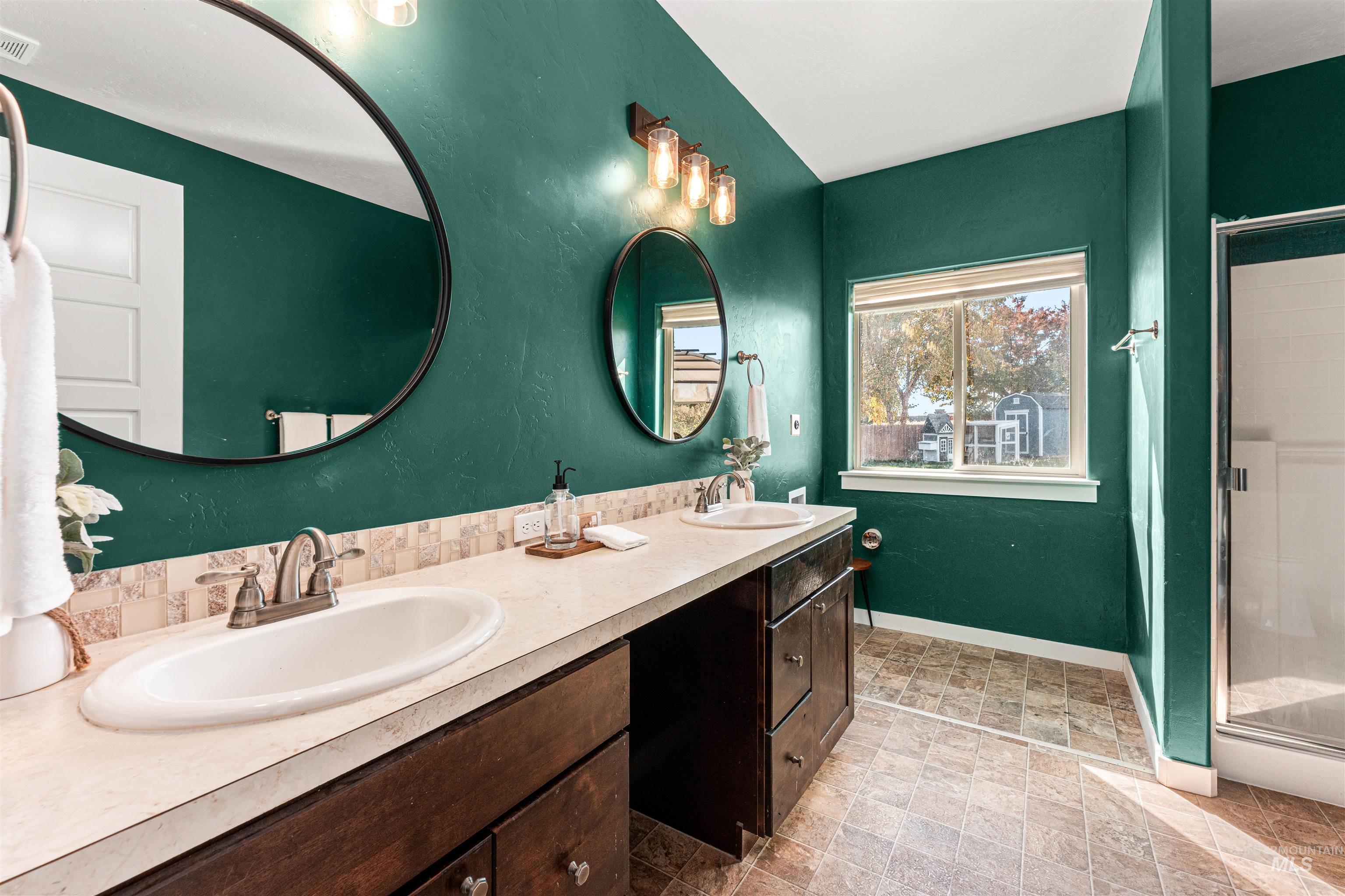 37 East Ensenada Drive Meridian, ID 83646 - Photo 20 of 46 Bathroom featuring a stall shower, double vanity, and a textured wall