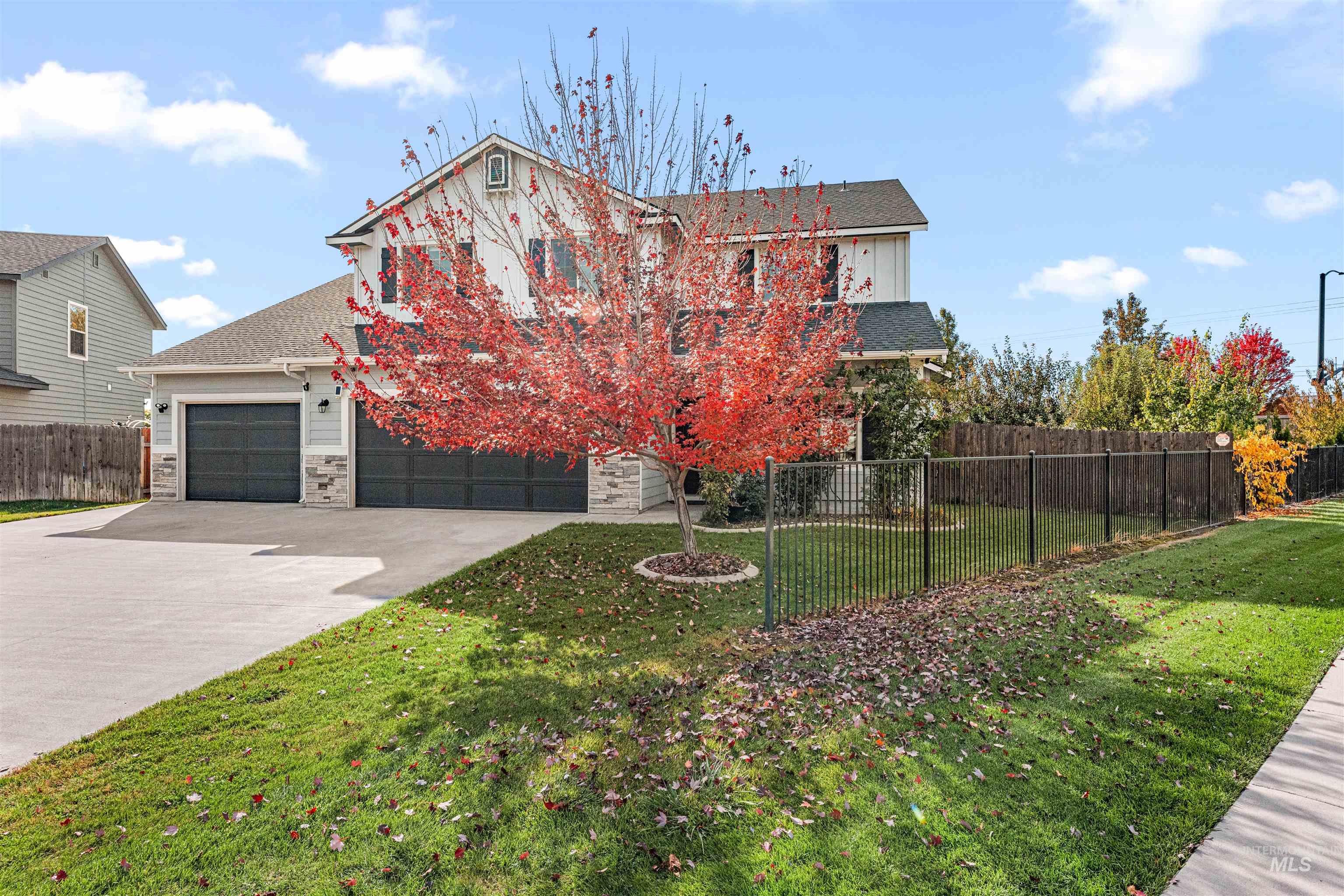 37 East Ensenada Drive Meridian, ID 83646 - Photo 2 of 46 View of front facade with stone siding, driveway, a garage, and a shingled roof