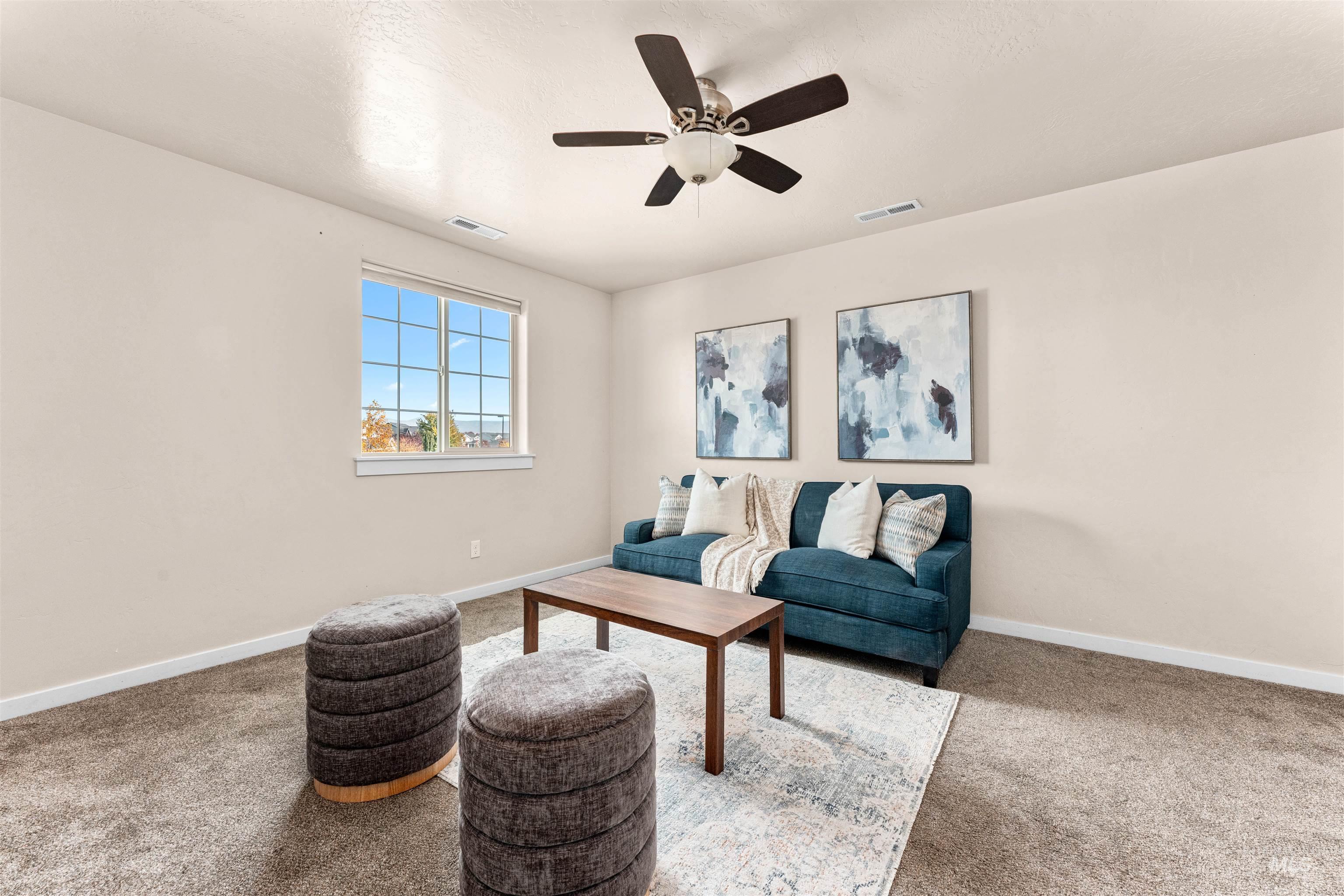 37 East Ensenada Drive Meridian, ID 83646 - Photo 22 of 46 Living area featuring light carpet and a ceiling fan