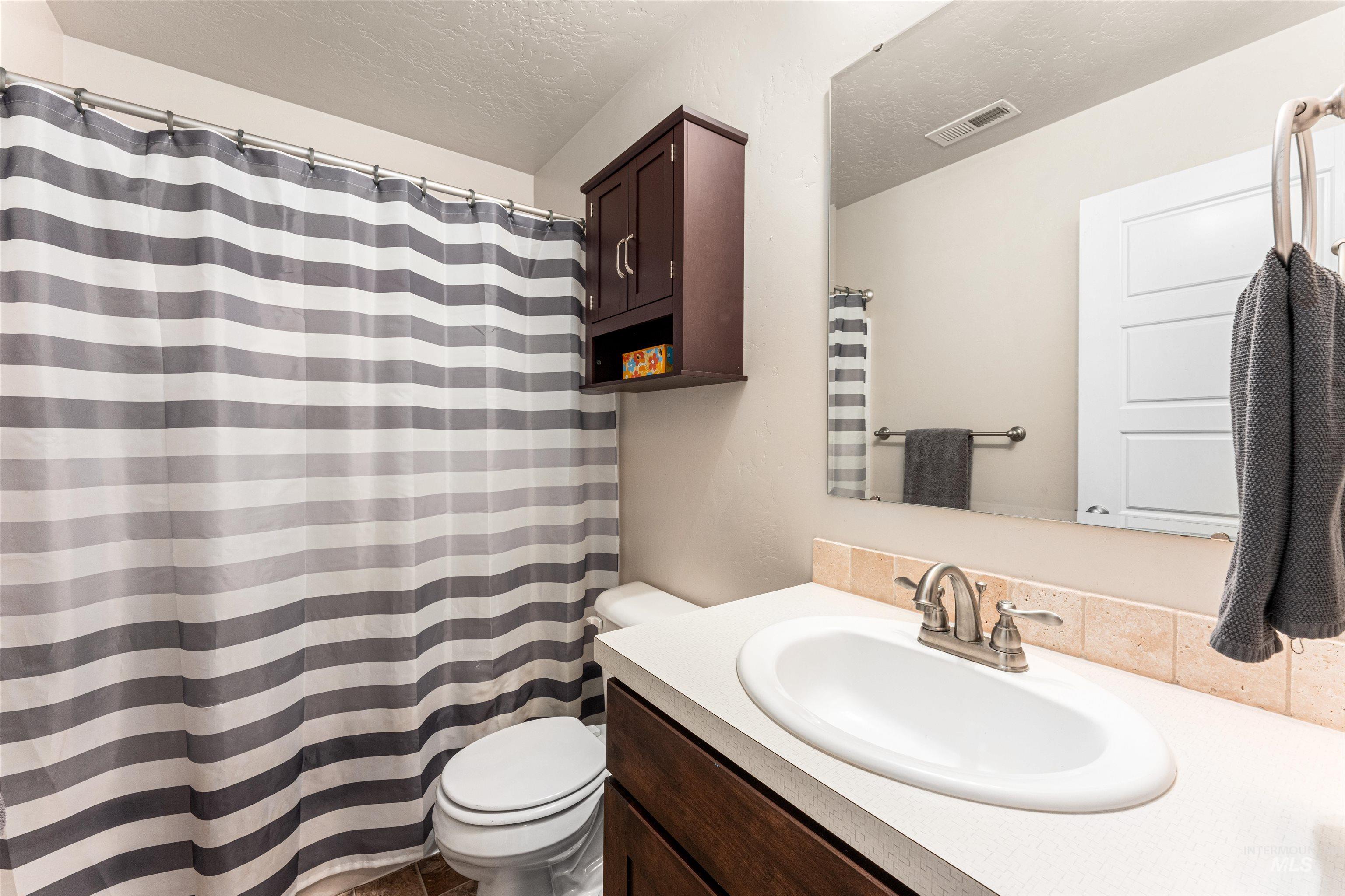37 East Ensenada Drive Meridian, ID 83646 - Photo 28 of 46 Full bathroom featuring vanity, a textured ceiling, and a shower with shower curtain