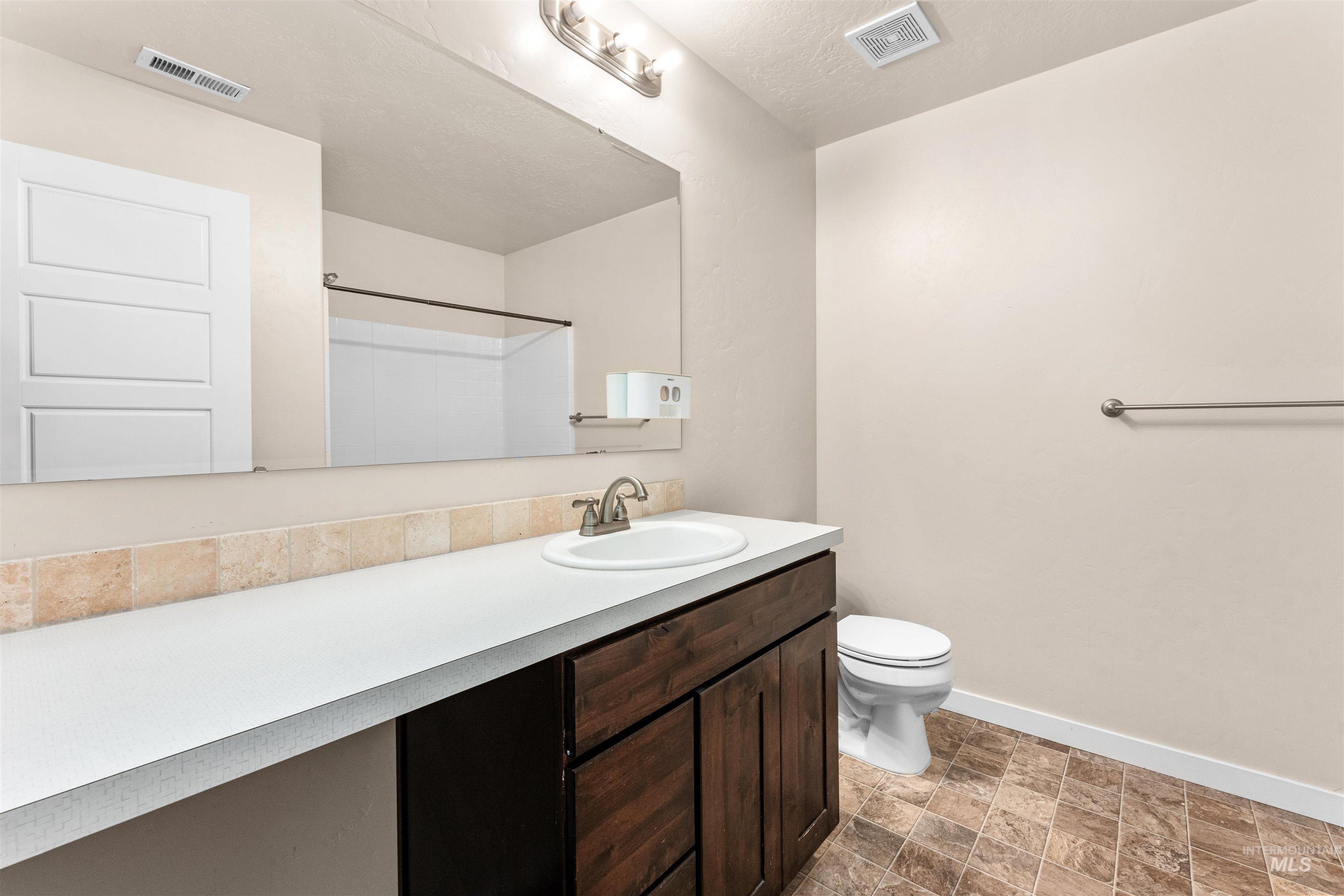 37 East Ensenada Drive Meridian, ID 83646 - Photo 36 of 46 Bathroom with vanity, stone finish flooring, and a shower