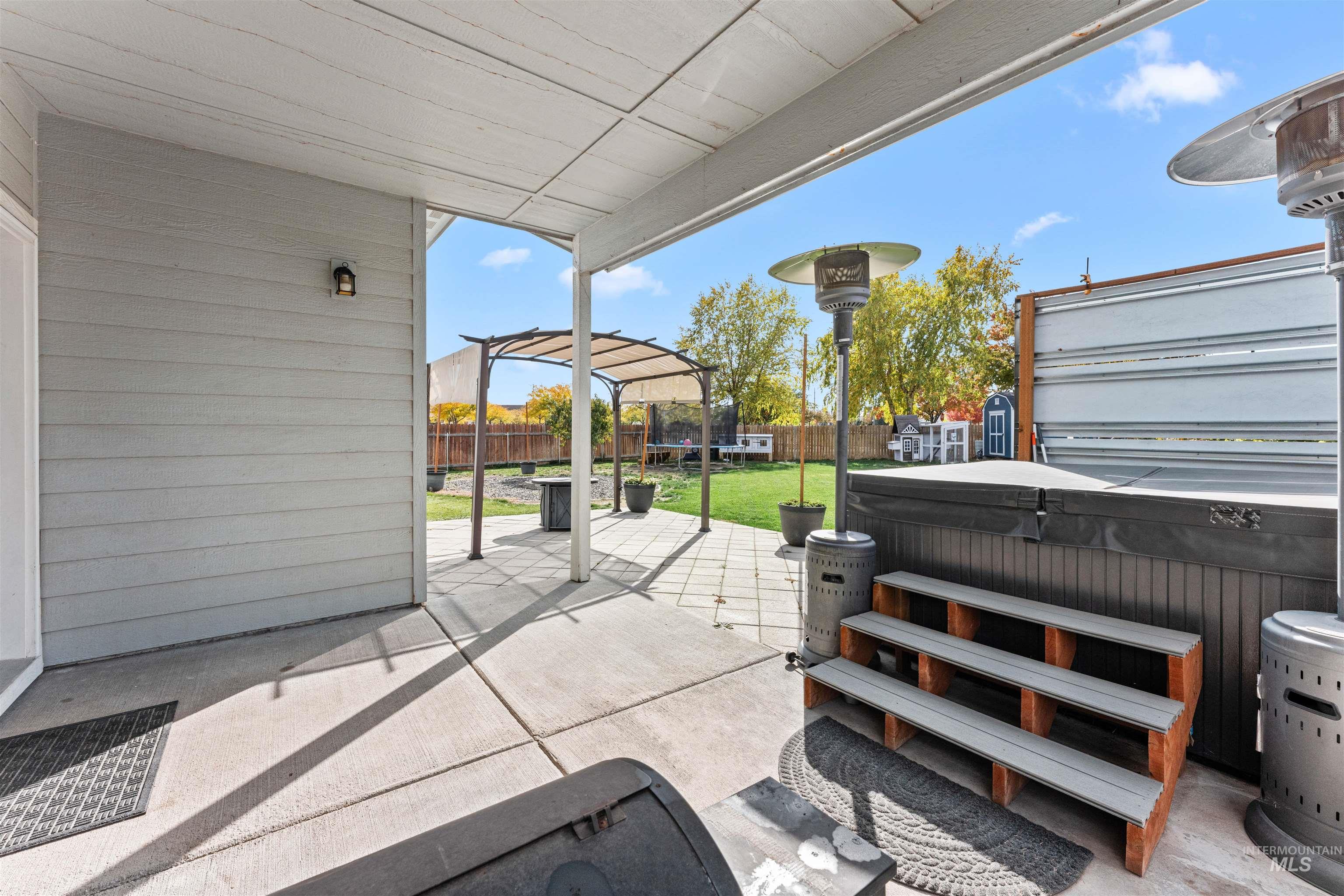 37 East Ensenada Drive Meridian, ID 83646 - Photo 40 of 46 Fenced backyard with a trampoline, a patio area, and a hot tub