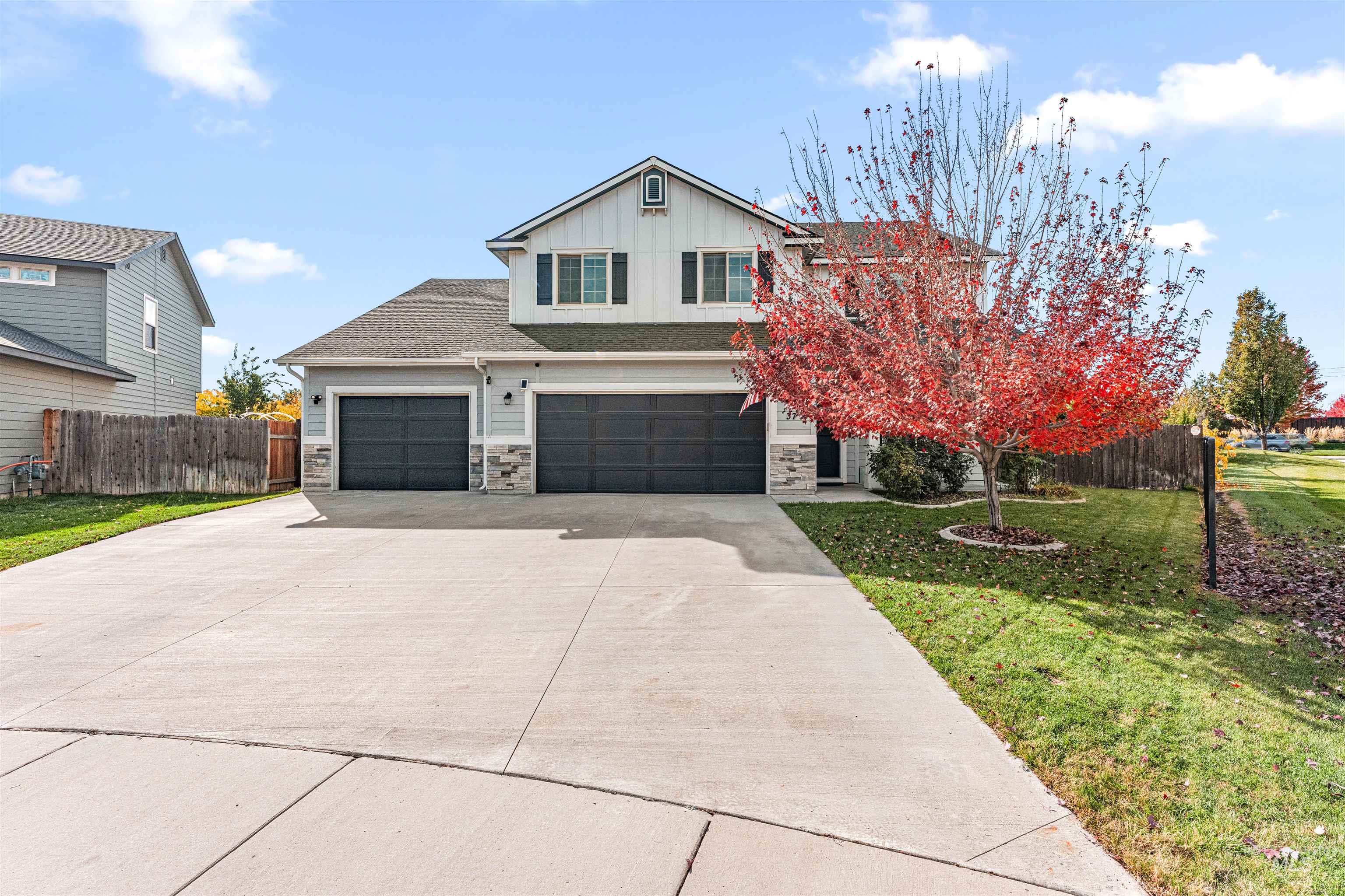 37 East Ensenada Drive Meridian, ID 83646 - Photo 41 of 46 View of front of property featuring stone siding, concrete driveway, board and batten siding, and a shingled roof