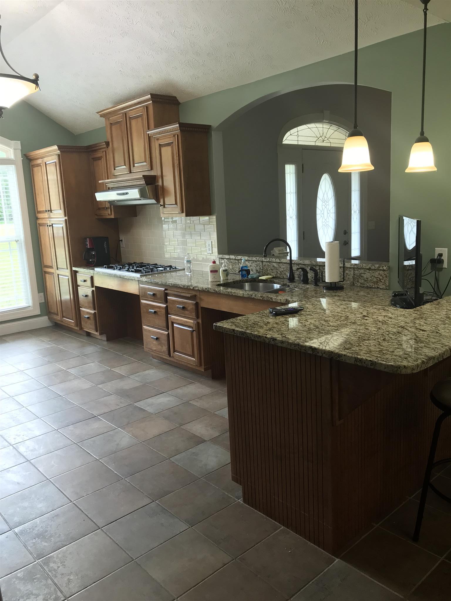 1276 Espy Road Manchester, TN 37355 - Photo 5 of 25 a kitchen with kitchen island granite countertop a stove a sink a oven and a dining table
