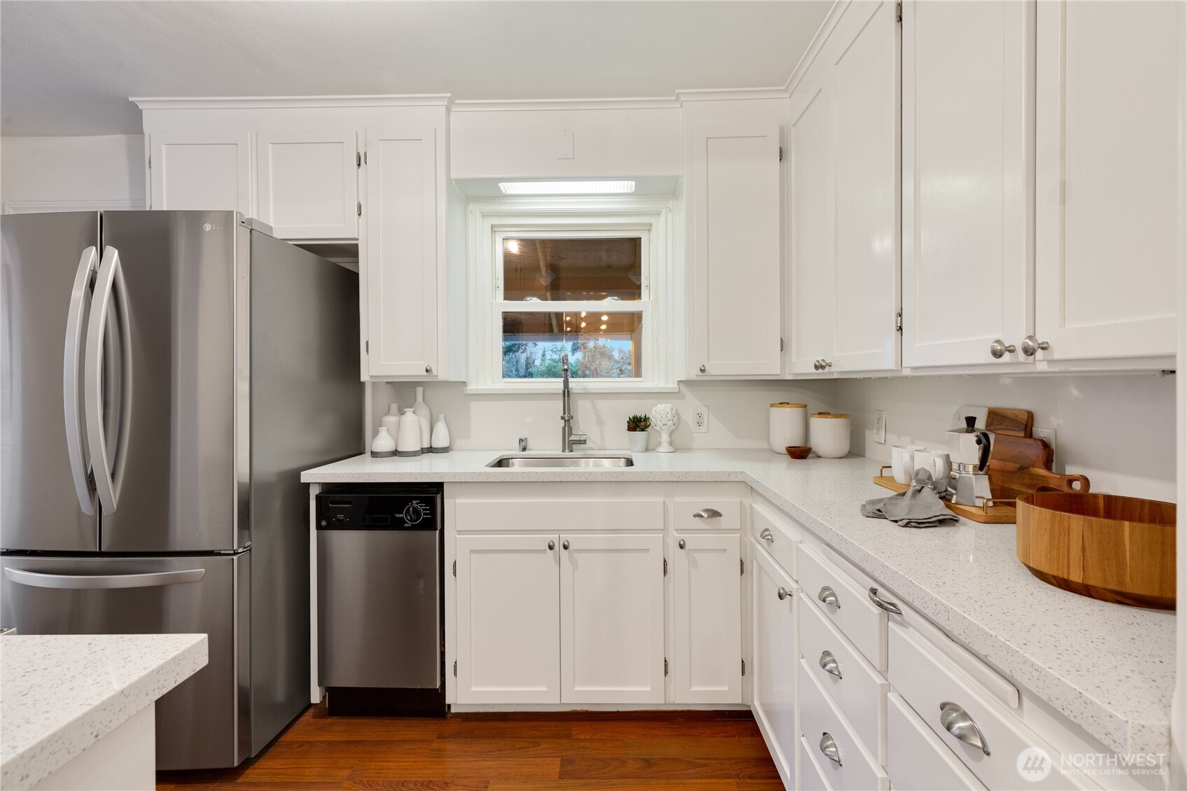 16406 Sylvester Road Southwest Burien, WA 98166 - Photo 7 of 28 a kitchen with white cabinets and stainless steel appliances