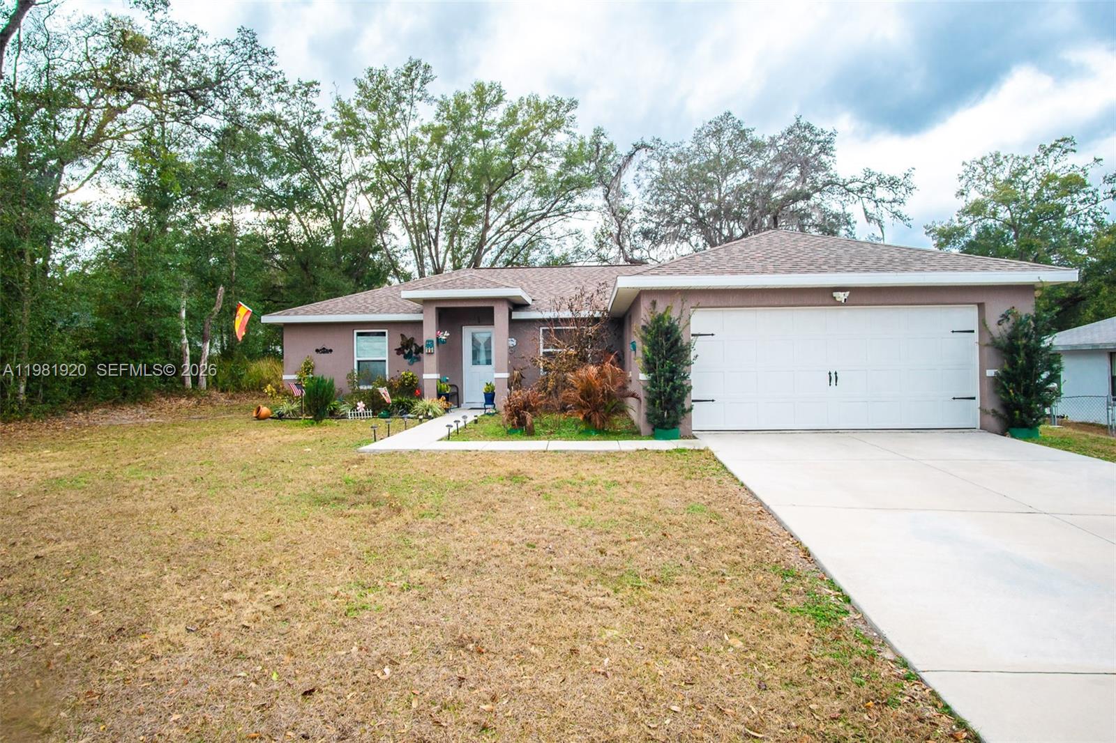 1123 East Bucknell Avenue Inverness, FL 34450 - Photo 1 of 13 a view of a house with a yard and large tree