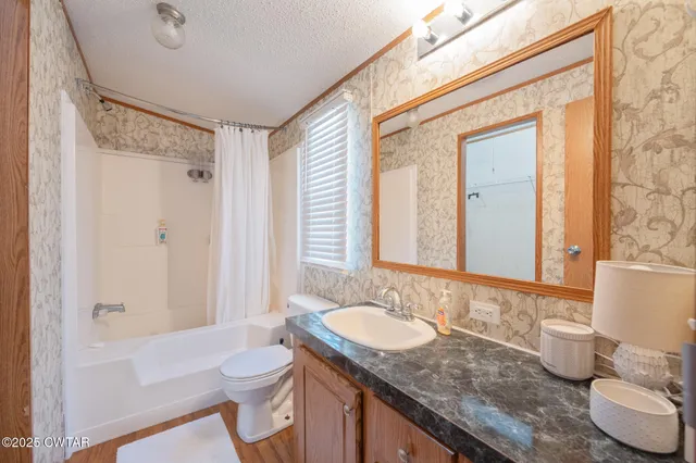 a bathroom with a granite countertop sink toilet a mirror and shower