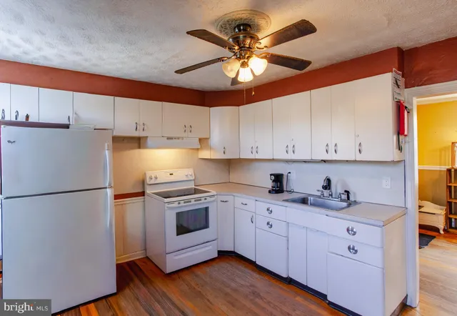 a kitchen with a sink a refrigerator and cabinets