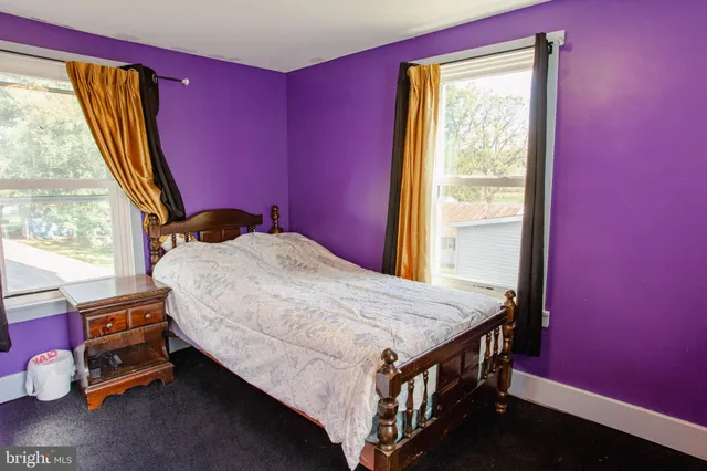 a bed sitting in a bedroom next to a window