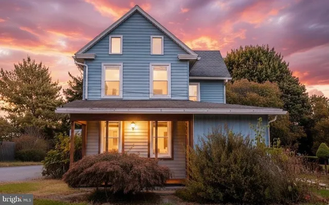 a view of a house with a small yard plants and large tree