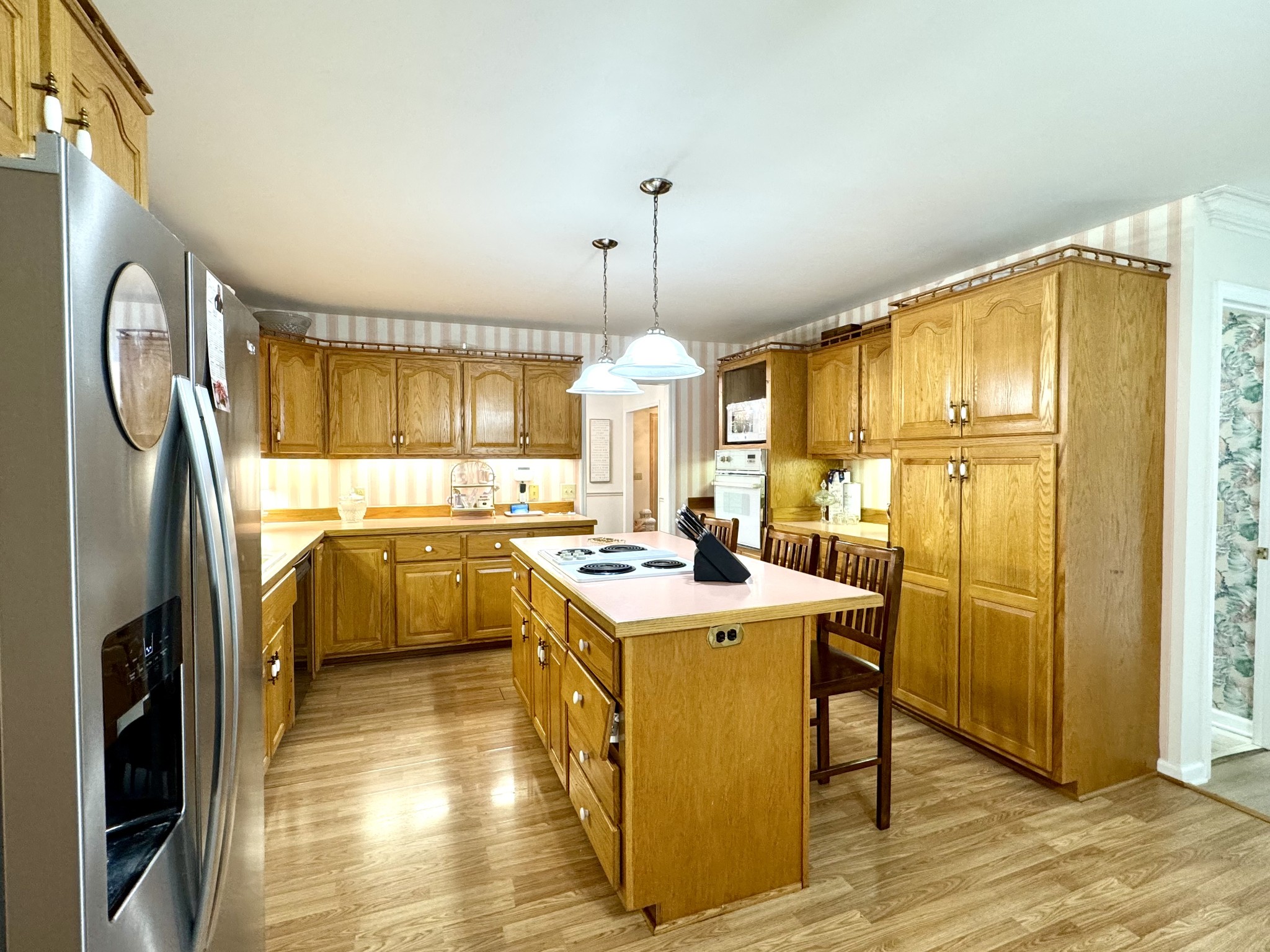 471 Old Pond Lane Dickson, TN 37055 - Photo 5 of 46 a kitchen with a refrigerator a sink dishwasher a stove and a dining table with wooden floor