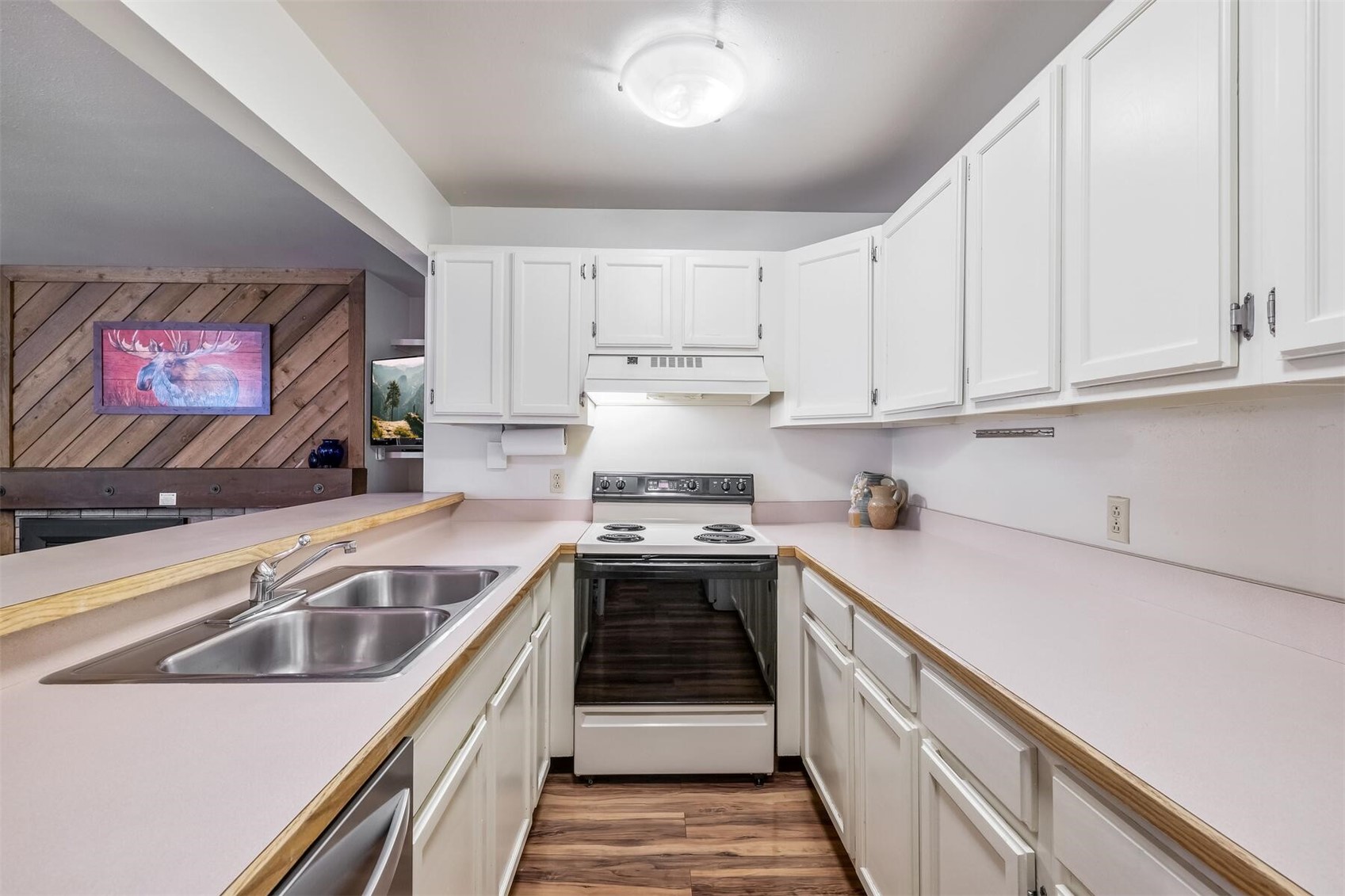 100 Wild Irishman Road, Unit 1103 Keystone, CO 80435 - Photo 9 of 33 Kitchen with white range with electric stovetop, custom range hood, hardwood / wood-style flooring, white cabinets, and sink