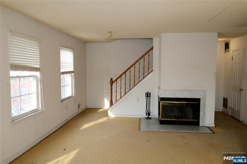 12 Rutgers Drive Newark, NJ 07103 - Photo 10 of 23 a view of an empty room with wooden floor fireplace and a window